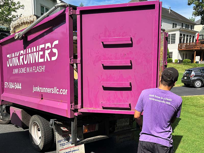 Junk Runners team member loading up junk removal truck
